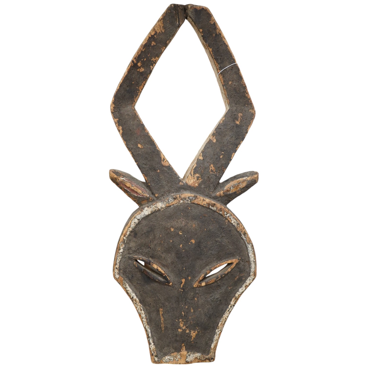 A Kwele painted wood mask in the form of an antelope’s head, 68cm high. Condition - fair, some paint loss.